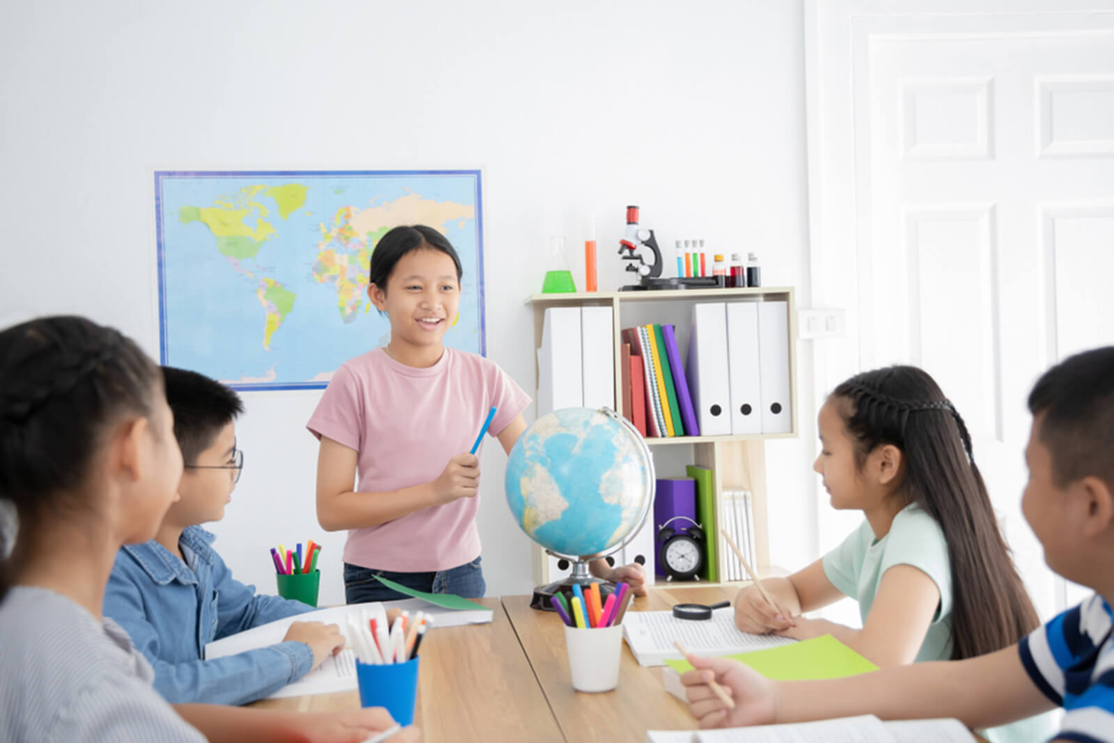 Khích lệ trẻ phát biểu ý kiến trong lớp, tham gia câu lạc bộ, hoặc trình bày ý tưởng trước tập thể là các cách giúp trẻ phát triển về tương tác xã hội.